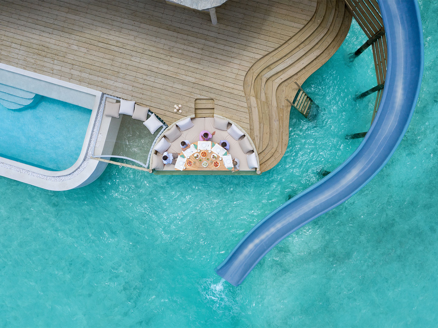 Slide into the ocean in the Maldives from an over-water villa